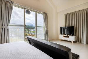 a bedroom with a bed and a flat screen tv at 旅居Villa in Dongshan