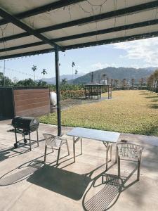 a picnic table and two chairs and a grill at 旅居Villa in Dongshan