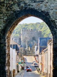 an archway over a street with a castle in the background at Stylish 4 bed in Central Conwy in Conwy