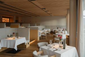 een eetkamer met witte tafels en stoelen bij Niedermair Nature Retreat in Parcines