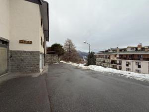 an empty street with snow on the side of a building at Neve 5 Apartment - Clotes Slope Access in Sauze d'Oulx