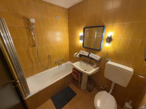 a bathroom with a tub and a sink and a toilet at Neve 5 Apartment - Clotes Slope Access in Sauze d'Oulx