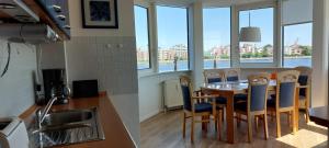 a kitchen and dining room with a table and chairs at Exklusive Ferienwohnung am Südstrand mit Wintergarten & Hafenblick Wohnung 113 in Wilhelmshaven +7 photos