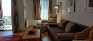 a living room with a couch and a coffee table at Exklusive Ferienwohnung am Südstrand mit Wintergarten, Balkon & Meerblick Wohnung 22 in Wilhelmshaven