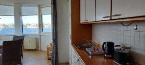 a kitchen with a sink and a counter top at Exklusive Ferienwohnung am Südstrand mit Wintergarten, Balkon & Meerblick Wohnung 22 in Wilhelmshaven +11 photos