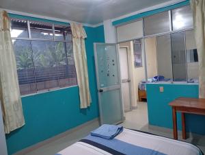 een blauwe kamer met een bed en een raam bij Airbn b Estancia ALVARADO 1 in Tingo María