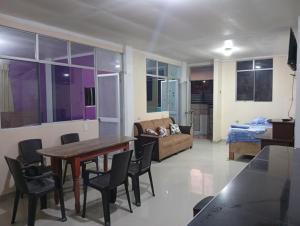 een woonkamer met een tafel, stoelen en een bank bij Airbn b Estancia ALVARADO 1 in Tingo María