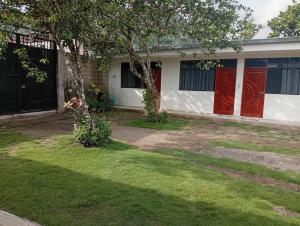een huis met rode deuren en een grasveld bij Airbn b Estancia ALVARADO 1 in Tingo María