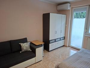 a living room with a couch and a cabinet at Benett Apartman in Győr