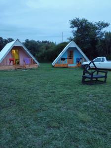 two tents with a car parked in a field at Dam Jam Cabanas in Oranjeville +5 photos