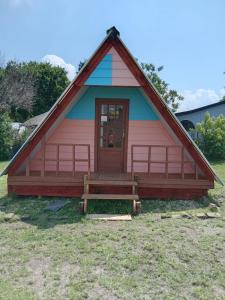 a red and blue house with a porch at Dam Jam Cabanas in Oranjeville