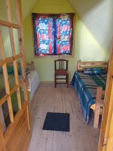 a bedroom with a bed and a window and a chair at Dam Jam Cabanas in Oranjeville