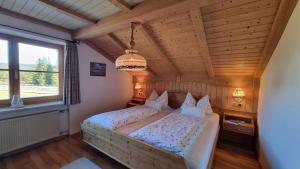 a bedroom with a large bed with a wooden ceiling at Ferienhaus Alpenzauber in Krün