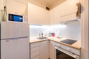 una cucina con mobili bianchi e un frigorifero bianco di Studio in the city center FREE PRIVATE PARKING with heating plug a Kemi
