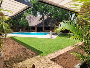 a backyard with a swimming pool and a lawn at Green Haven Guest Lodge in Pretoria