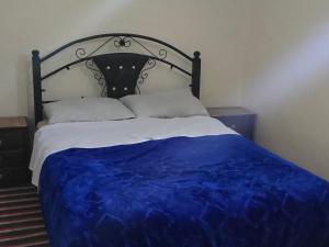a bedroom with a bed with a blue comforter at tigmi oufla in Taghazout