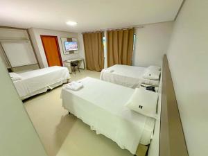 ein Krankenzimmer mit zwei Betten und einem Spiegel in der Unterkunft Hotel Ideal 5 in Araguaína