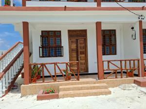 a small house with stairs and a door at Karibu House Bwejuu in Bwejuu