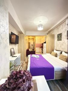 a hotel room with a large bed with purple sheets at Studios & Apartments Palas by Glam at Lazar Towers in Iaşi