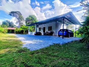 a house with a car parked in front of it at Sri Nawa Homestay in Pokok Sena