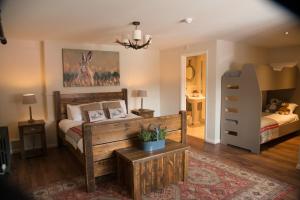 a bedroom with a bed and a dresser at The Swan Hotel, Alresford in Winchester