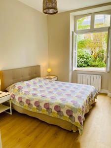 een slaapkamer met een groot bed en een raam bij Le Gîte Du Parc avec parking vieux port et plage au calme in La Rochelle