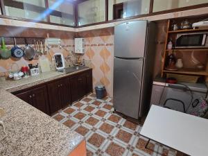 a kitchen with a stainless steel refrigerator and a tile floor at tigmi oufla in Taghazout