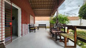 a row of benches sitting on a porch at GRA325 | Spacious Retreat with Pool and Barbecue. in Gravatá