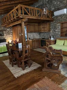 a room with a table and chairs and a kitchen at Petrina Theohari in Lekhoúrion