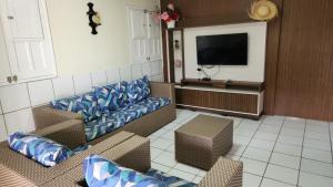 a living room with couches and a flat screen tv at GRA325 | Spacious Retreat with Pool and Barbecue. in Gravatá