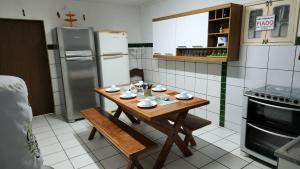 a kitchen with a wooden table and a refrigerator at GRA325 | Spacious Retreat with Pool and Barbecue. in Gravatá