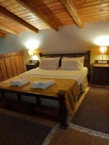 a bedroom with a large bed with two towels on it at Petrina Theohari in Lekhoúrion