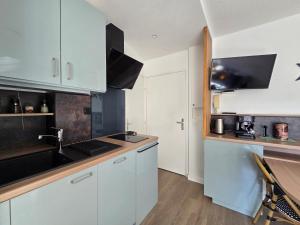 a kitchen with white cabinets and a sink at T2 cosy et rénové avec vue sur le port d'Argelès pour 4 personnes in Argelès-sur-Mer