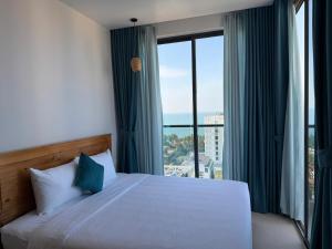 a bedroom with a bed and a large window at Alana Seaview by CKV - Free Airport Pick Up in Phu Quoc +26 photos