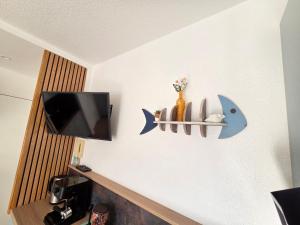 a room with a tv and a shelf with a fish on the wall at T2 cosy et rénové avec vue sur le port d'Argelès pour 4 personnes in Argelès-sur-Mer