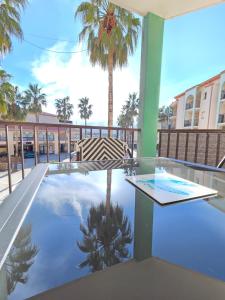 a swimming pool with a palm tree in a building at T2 cosy et rénové avec vue sur le port d'Argelès pour 4 personnes in Argelès-sur-Mer