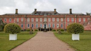 a large red brick building with two trees in front at ACCOMADATION WREXHAM in Wrexham