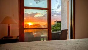 a room with a window with a view of a sunset at Lo de las Tías in Balneario Solís
