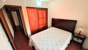 a small bedroom with a bed and a red door at Lo de las Tías in Balneario Solís +26 photos