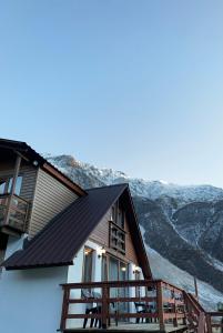 a house with a balcony and mountains in the background at old white house in Kazbegi