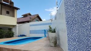a white fence with a swimming pool in a backyard at GRA325 | Spacious Retreat with Pool and Barbecue. in Gravatá