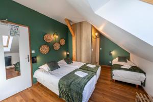 two beds in a room with green walls at Gite Le Rebanchon in Le Monêtier-les-Bains
