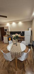 a table with white chairs and a vase with flowers on it at APART ALVARADO microcentro in Salta +11 photos