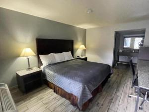 a bedroom with a bed and two lamps and a desk at Western Inn Marietta in Atlanta