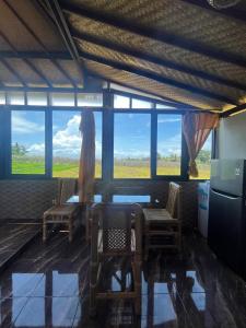 a room with two chairs and a table and windows at Tutwin Guesthouse in Krambitan