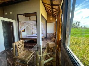 a room with a view of a bed and a window at Tutwin Guesthouse in Krambitan