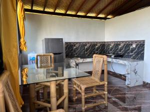 a kitchen with a glass table and two chairs at Tutwin Guesthouse in Krambitan