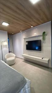 a living room with a flat screen tv on a wall at Condômino Max life in Pipa