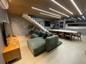 a living room with a green couch and a table at Condômino Max life in Pipa