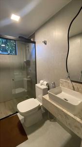 a bathroom with a toilet and a sink and a shower at Condômino Max life in Pipa +14 photos